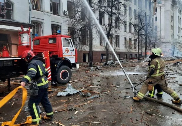 Bombeiros tentando apagar incêndio provocado por bombardeio russo