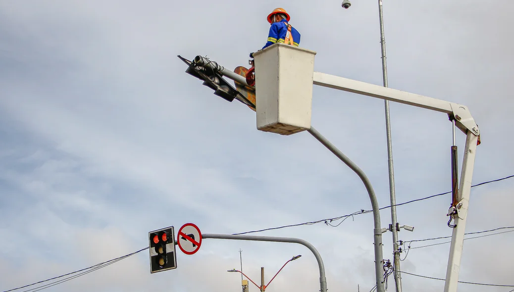 Equipes em manutenção do semáforo do cruzamento