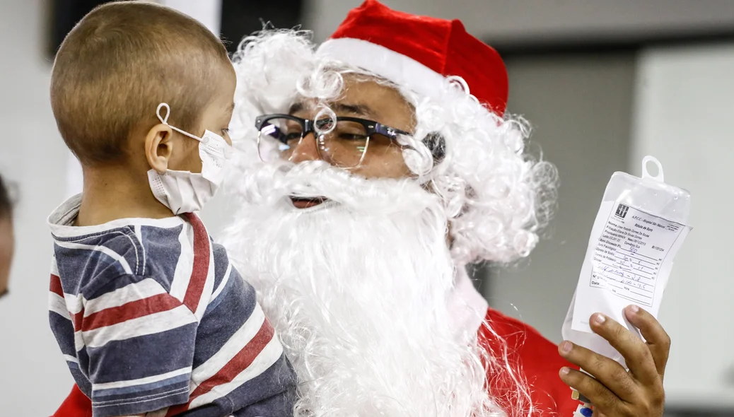 Criança recebendo o carinho do Papai Noel 