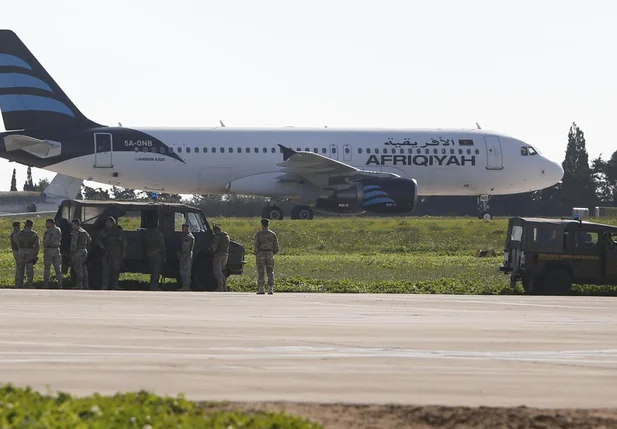 Tropas acompanham a inspeção do avião no aeroporto de Malta