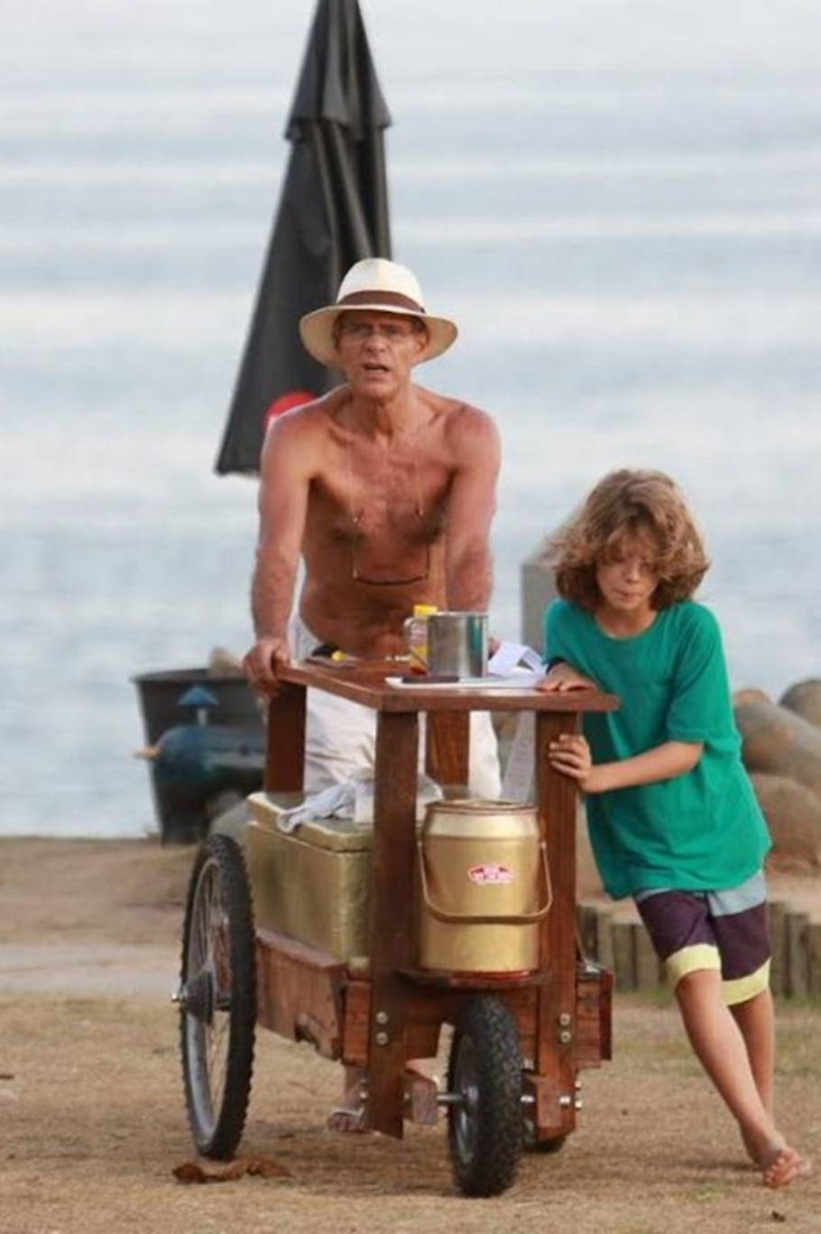 Ator Mário Gomes vendendo hambúrguer na praia com seu filho