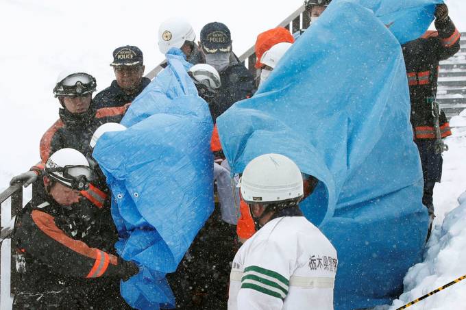 Funcionários resgatam vítimas de avalanche