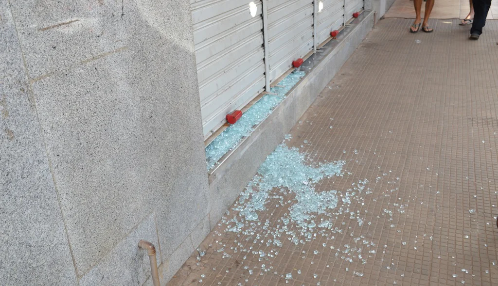 Manifestantes quebram vidraça de loja