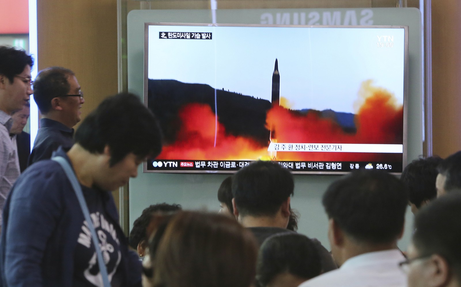   Pessoas assistem a programa de TV que mostra míssil lançado pela Coreia do Norte