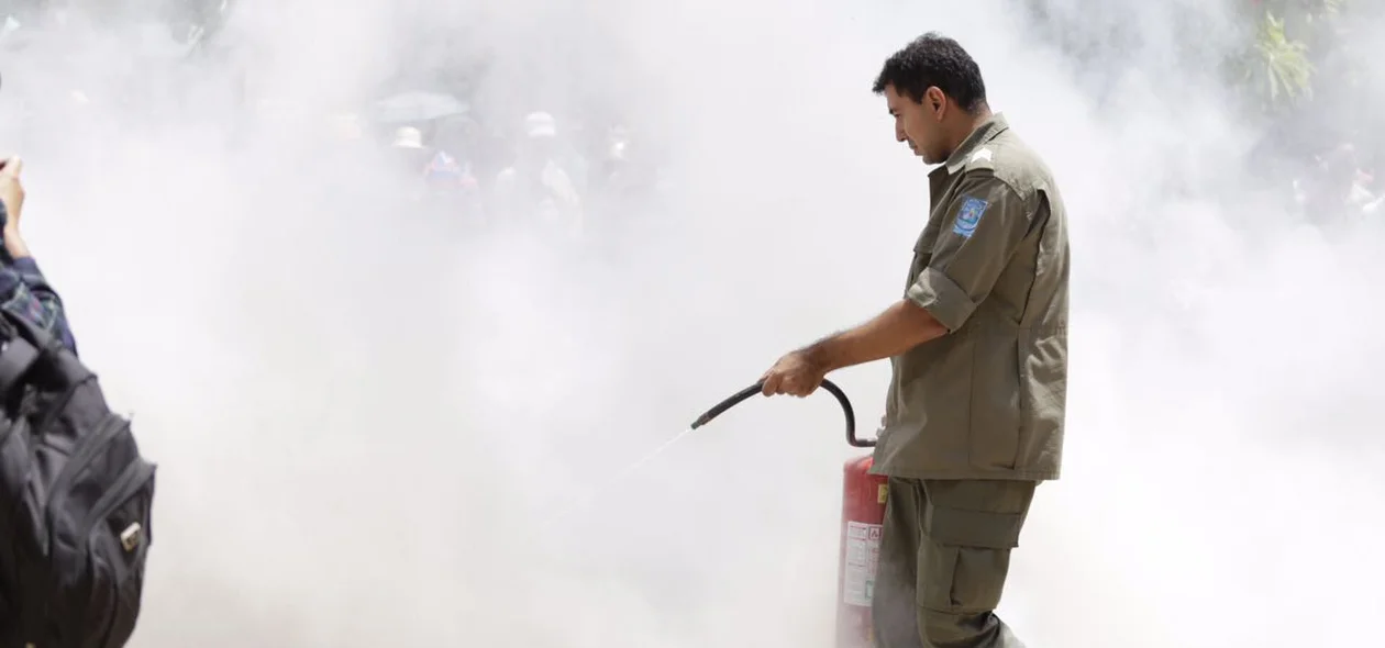 Policial militar tentando apagar o fogo em frente a Alepi