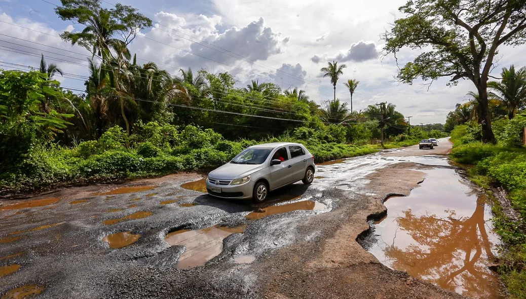 Carro passa com dificuldades pela buraqueira