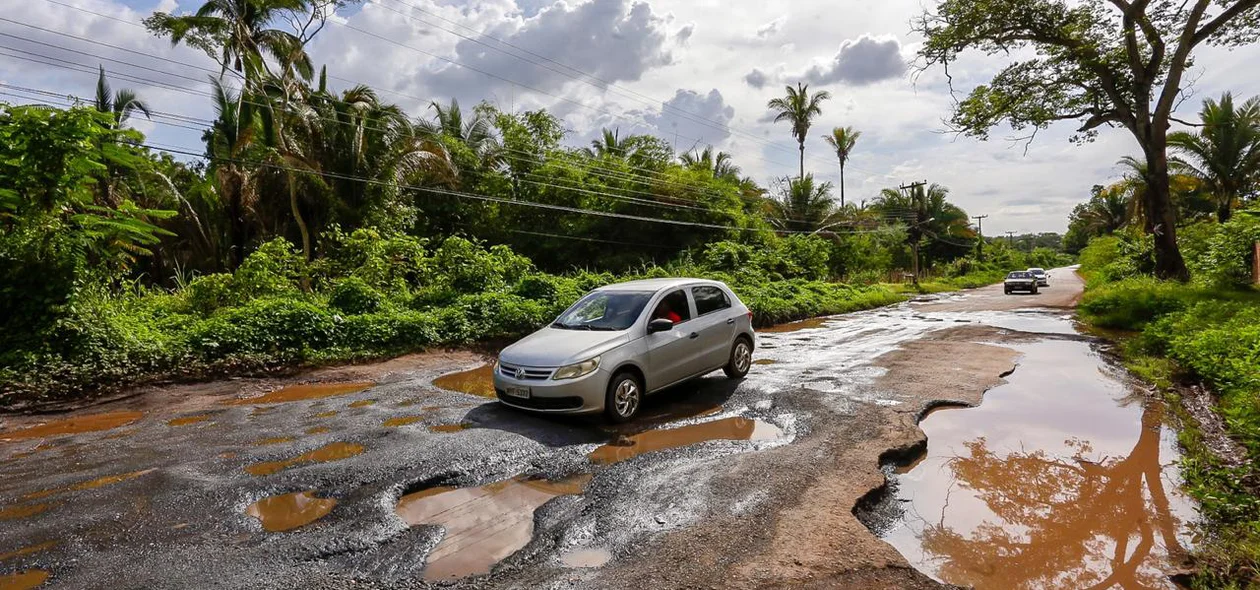 Carro passa com dificuldades pela buraqueira