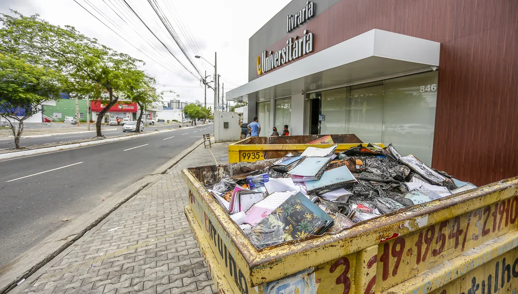 2 depósitos de lixo com material queimado da livraria