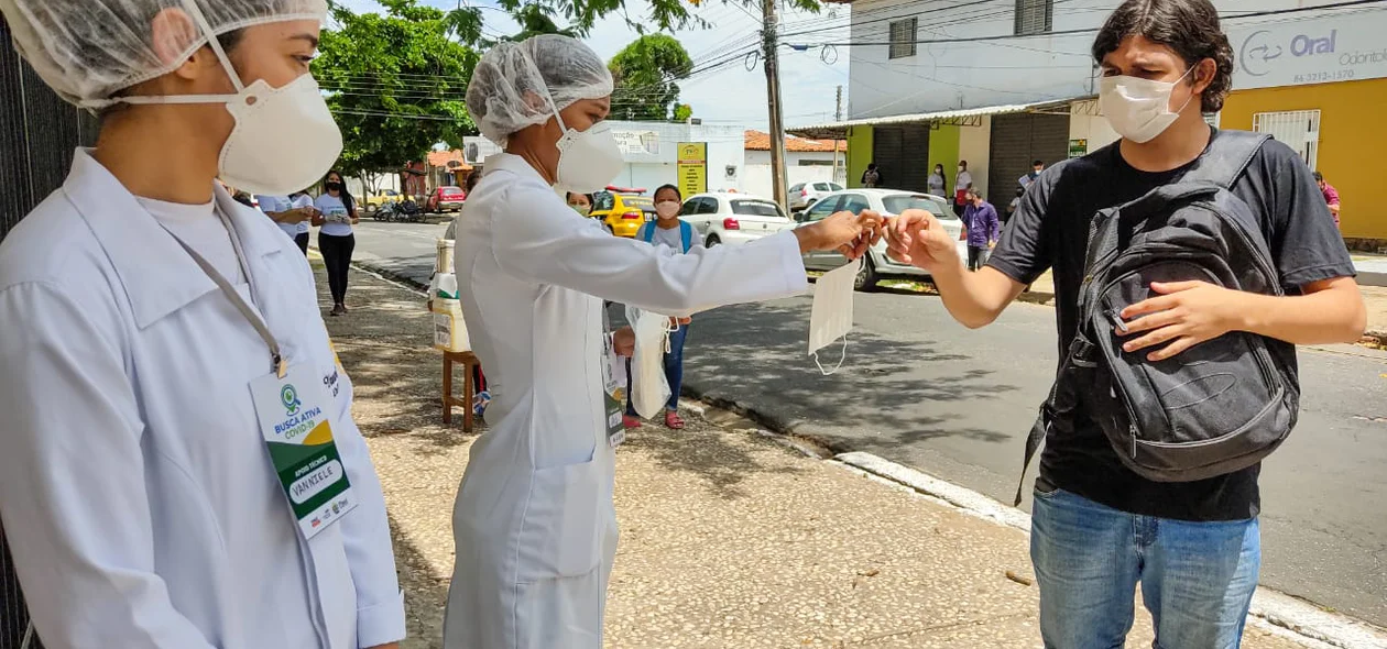 Estudante recebe máscara de proteção antes de entrar no local de prova do Enem