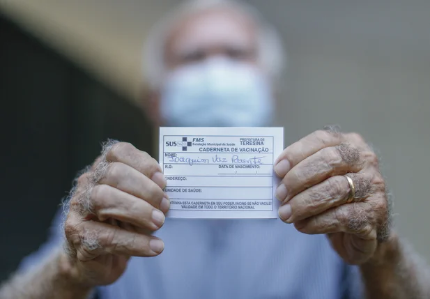 Joaquim Vaz Parente mostrando seu cartão de vacina