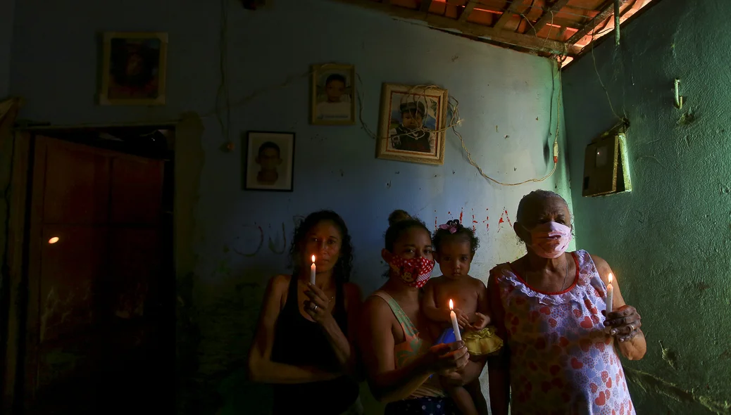 Moradores segurando velas