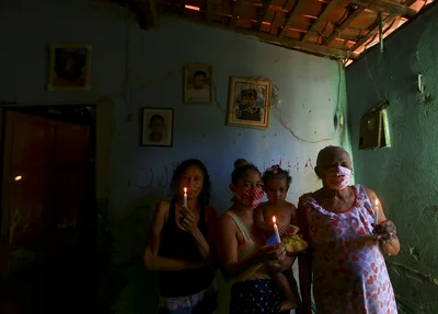 Moradores segurando velas