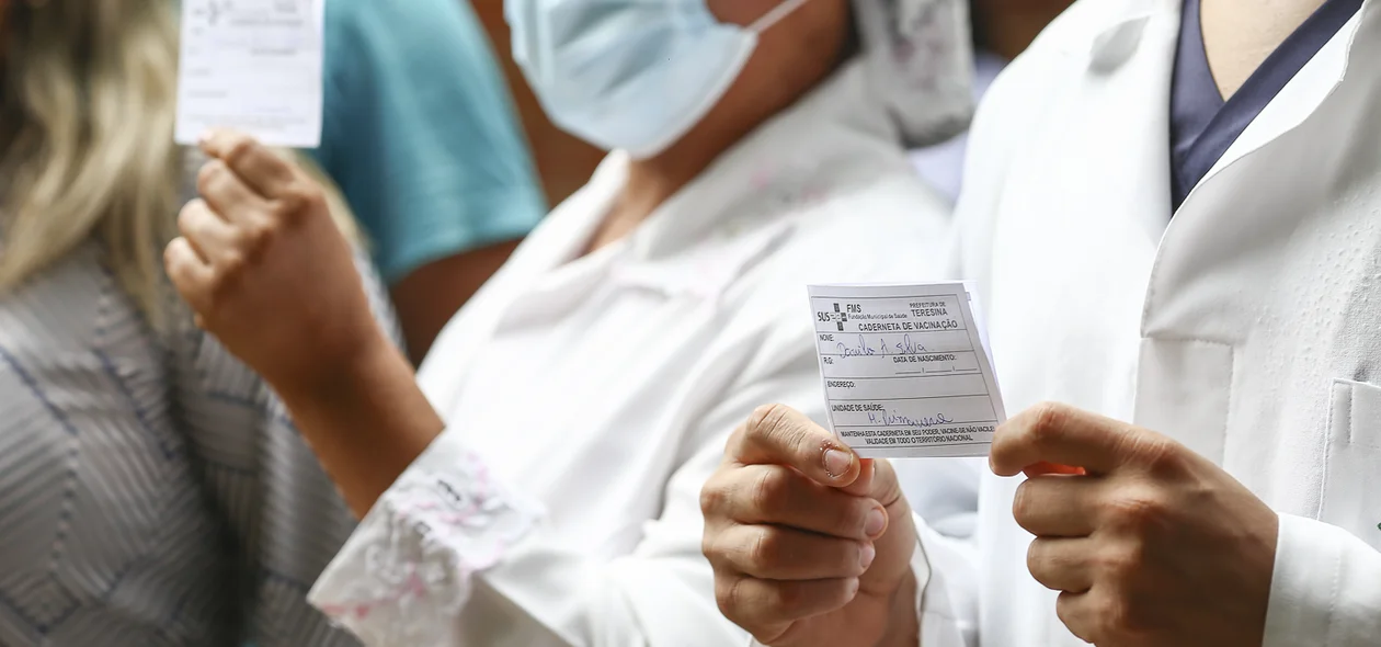 Vacinados mostrando o cartão de vacina