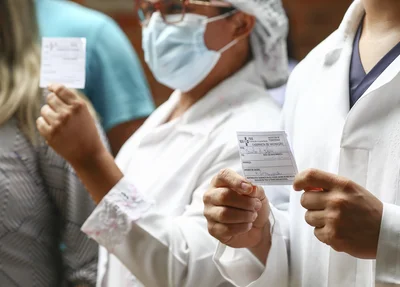 Vacinados mostrando o cartão de vacina