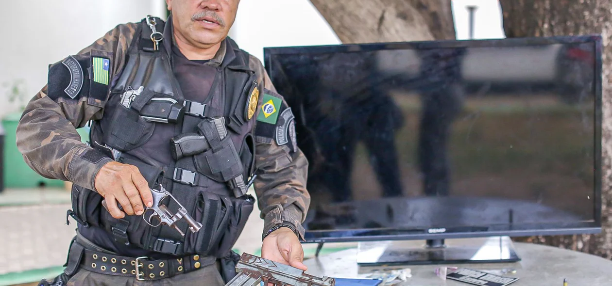 Cabo Mota ao lado dos materiais apreendidos