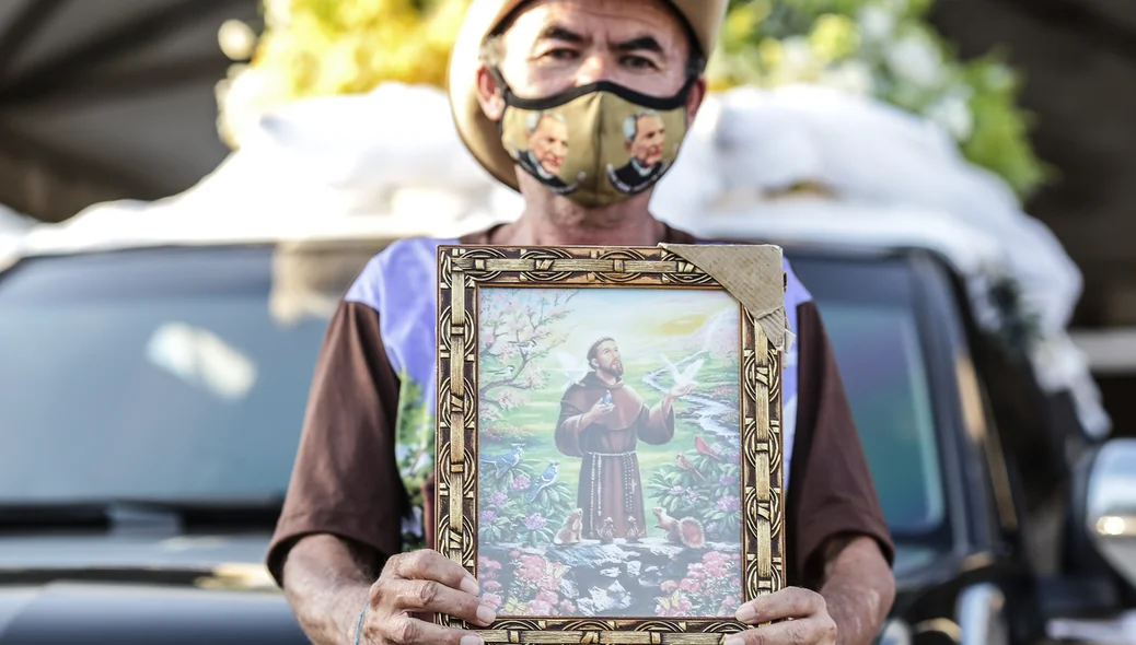 Senhor segurando quadro de São Francisco