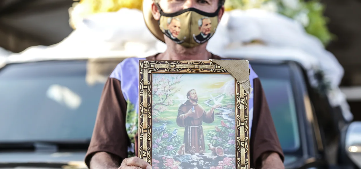 Senhor segurando quadro de São Francisco