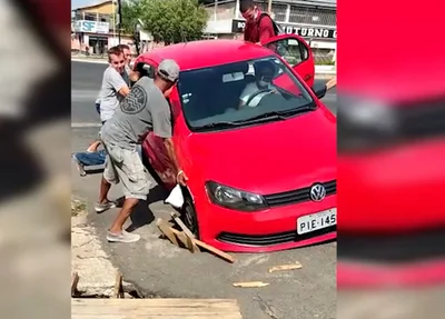 Veículo ficou preso e populares tiveram que retirar o carro no braço
