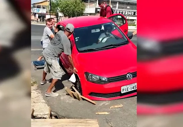 Veículo ficou preso e populares tiveram que retirar o carro no braço