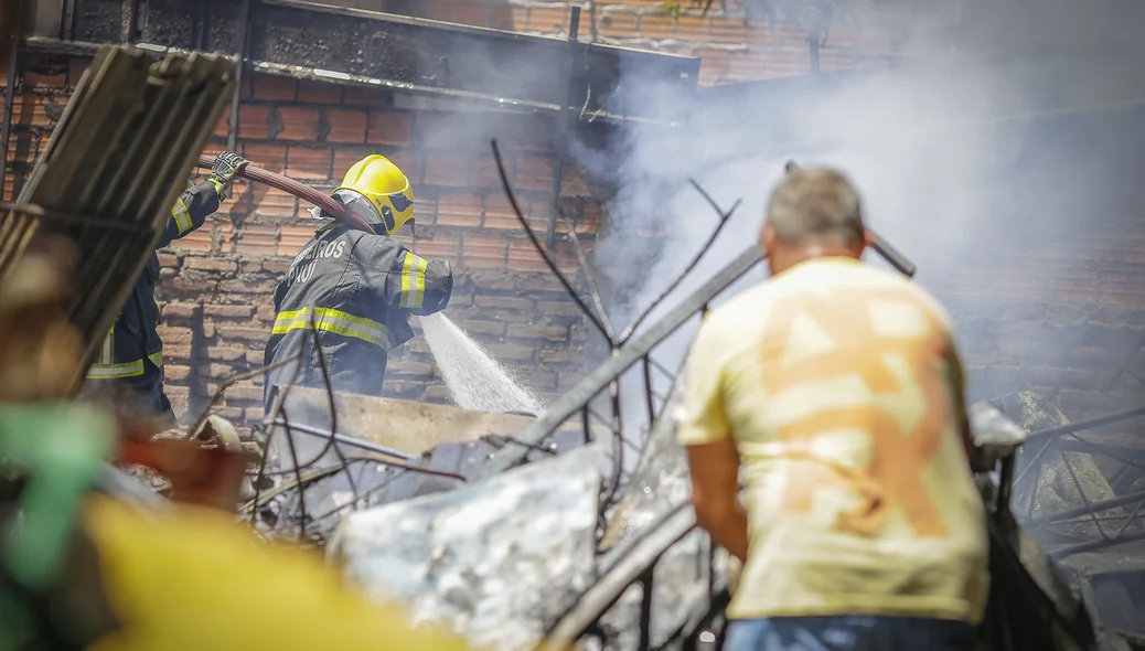 Bombeiro e popular ajudando a combater o fogo