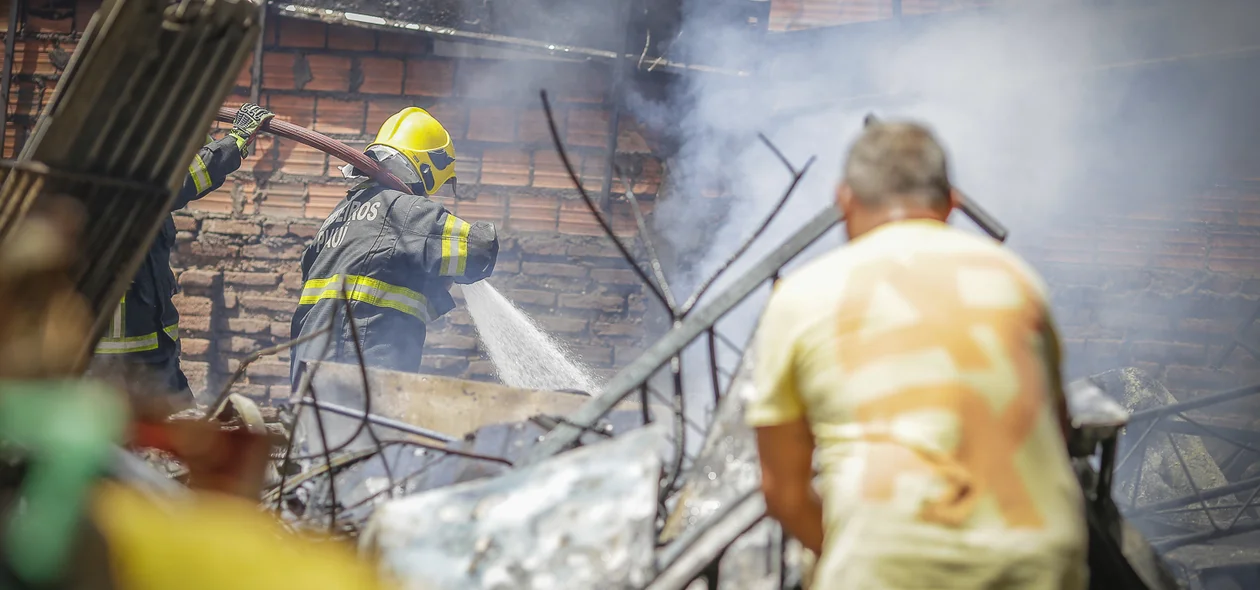 Bombeiro e popular ajudando a combater o fogo