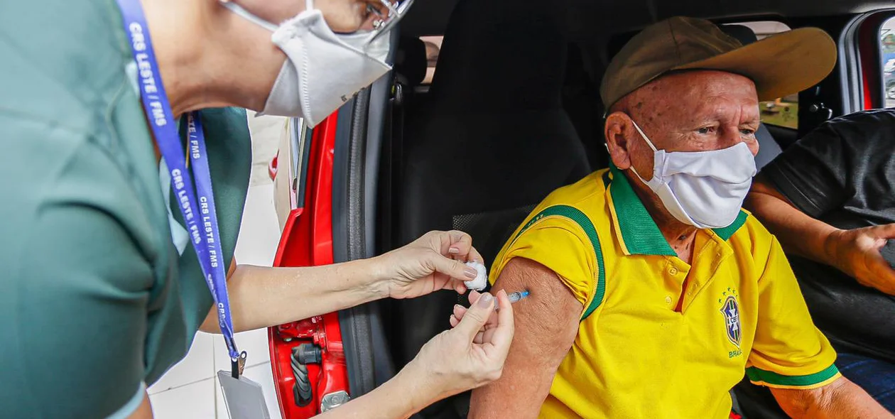 Idoso com camisa do Brasil sendo vacinado contra covid-19