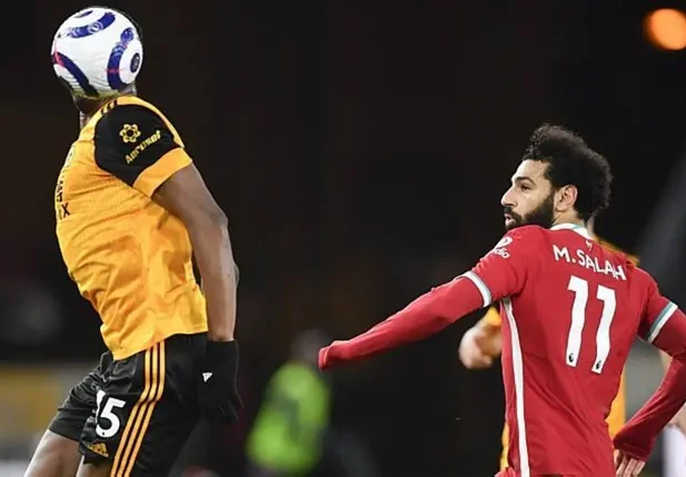 A bola esconde Willy Boly, do Wolverhampton, em disputa com Salah, do Liverpool