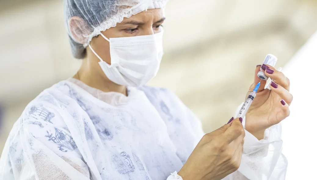 Enfermeira preparando a seringa para aplicar a vacina