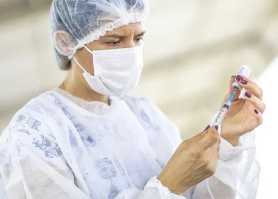 Enfermeira preparando a seringa para aplicar a vacina