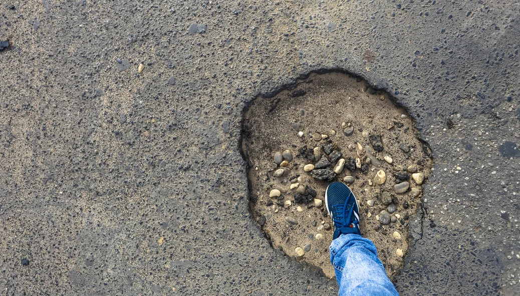 Morador colocou o pé para mostrar o tamanho do buraco