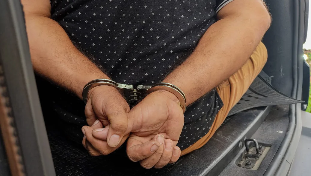 Empresário preso e algemado dentro da viatura