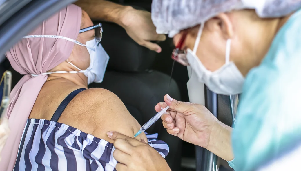 Senhora de 67 anos sendo vacinada