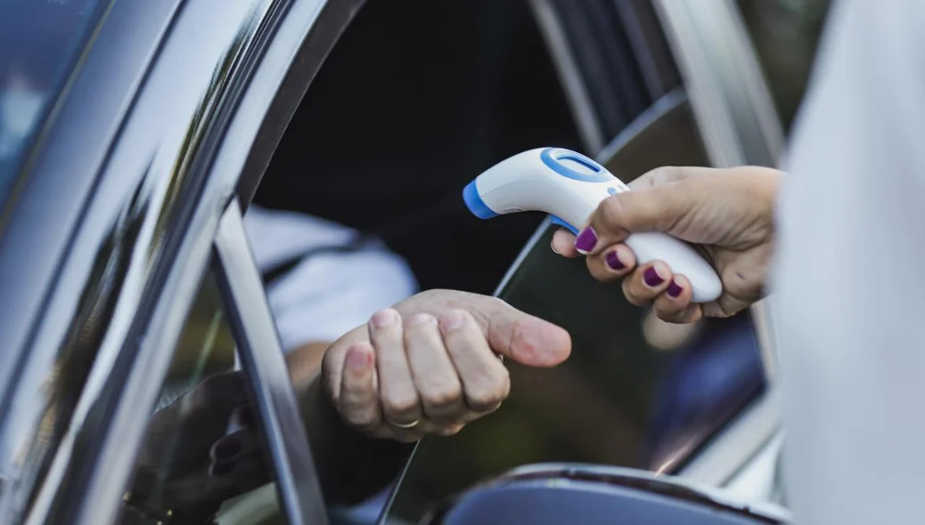 Equipe de Saúde aferindo a temperatura dos motoristas que passam pelo local