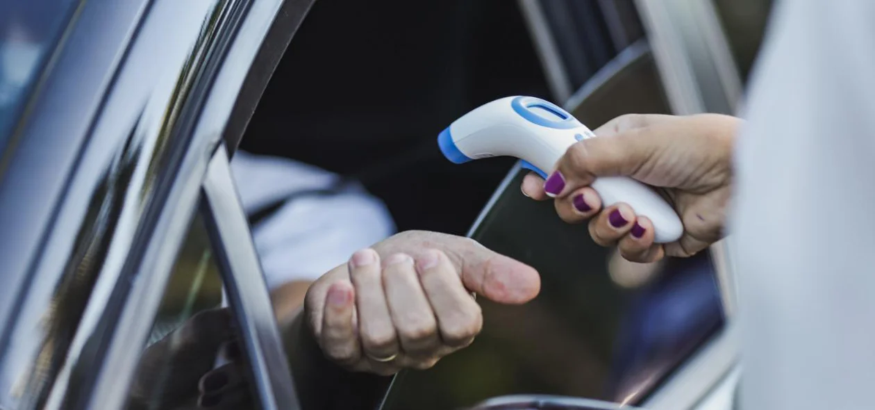 Equipe de Saúde aferindo a temperatura dos motoristas que passam pelo local