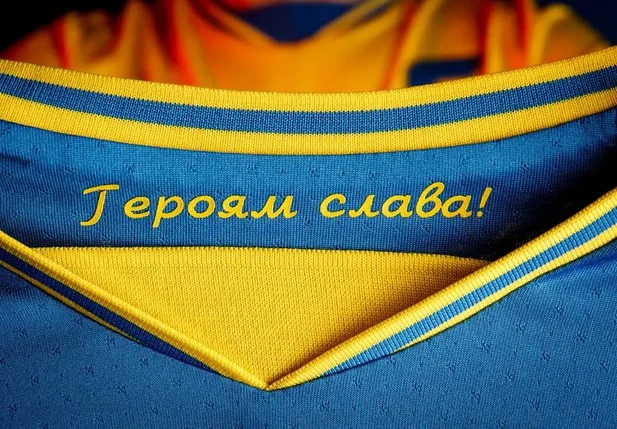 Detalhe da frase 'Glória aos Heróis', em cirílico, na gola interna da camisa da Ucrânia para a Euro.