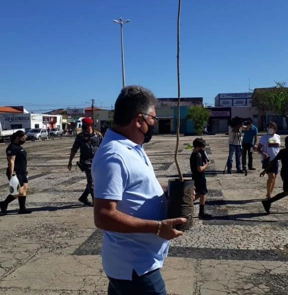 João Mádison com uma muda de planta
