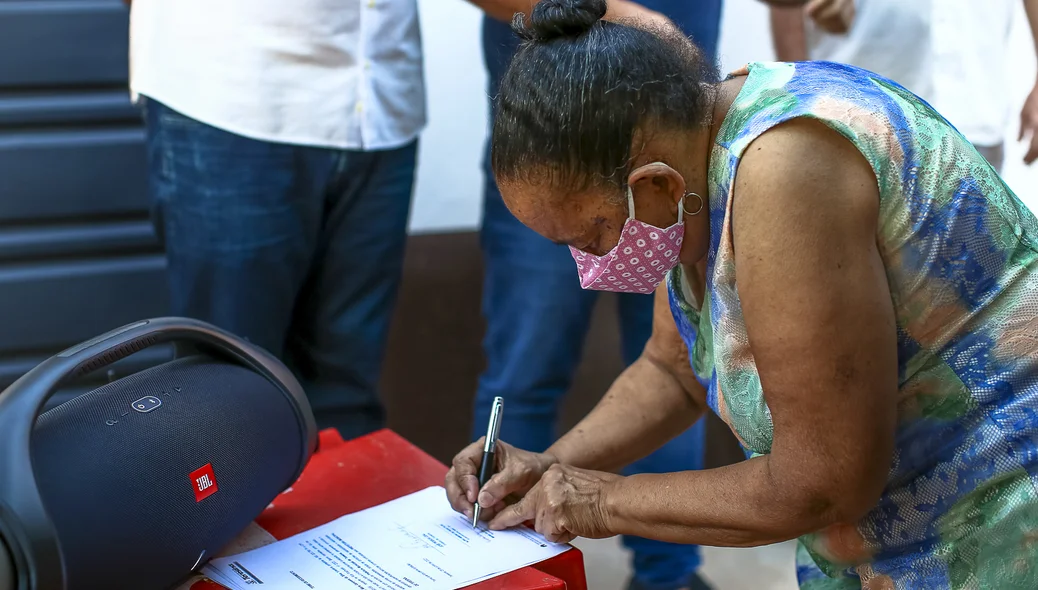 Maria da Cruz assinando o termo