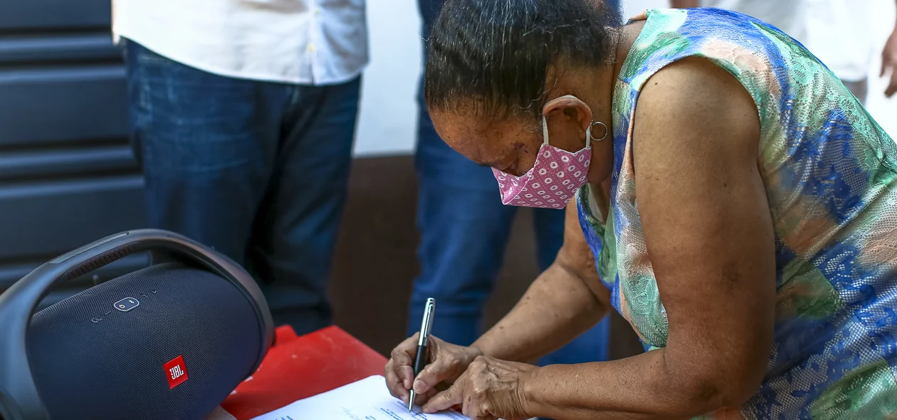 Maria da Cruz assinando o termo