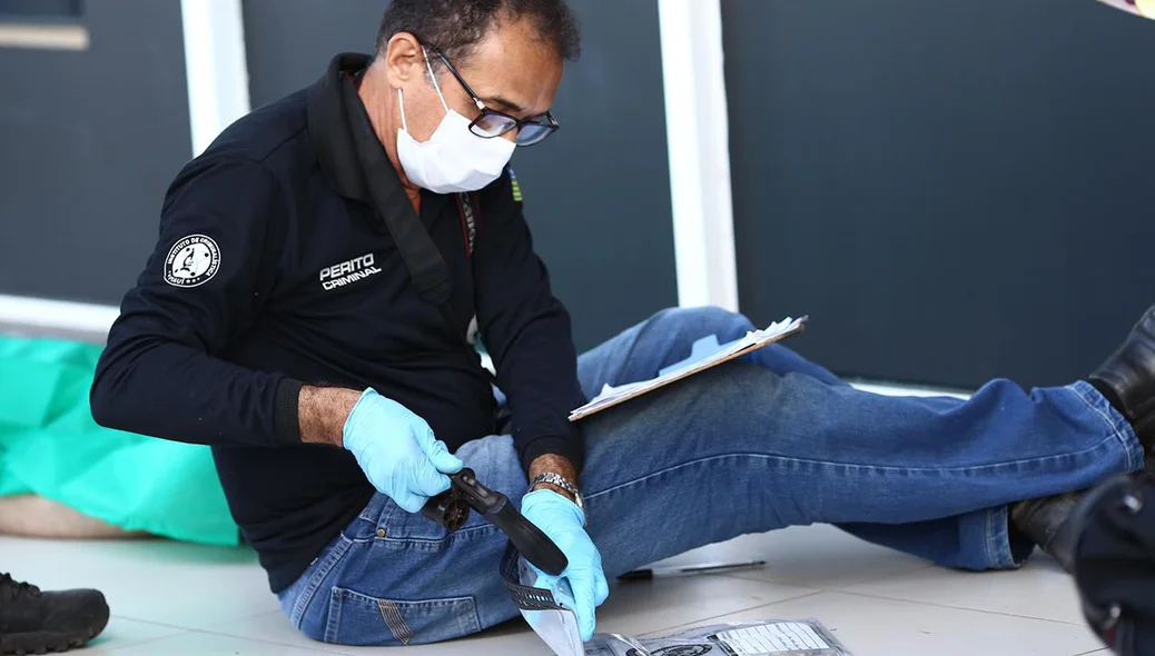 Perito recolhendo a arma do crime