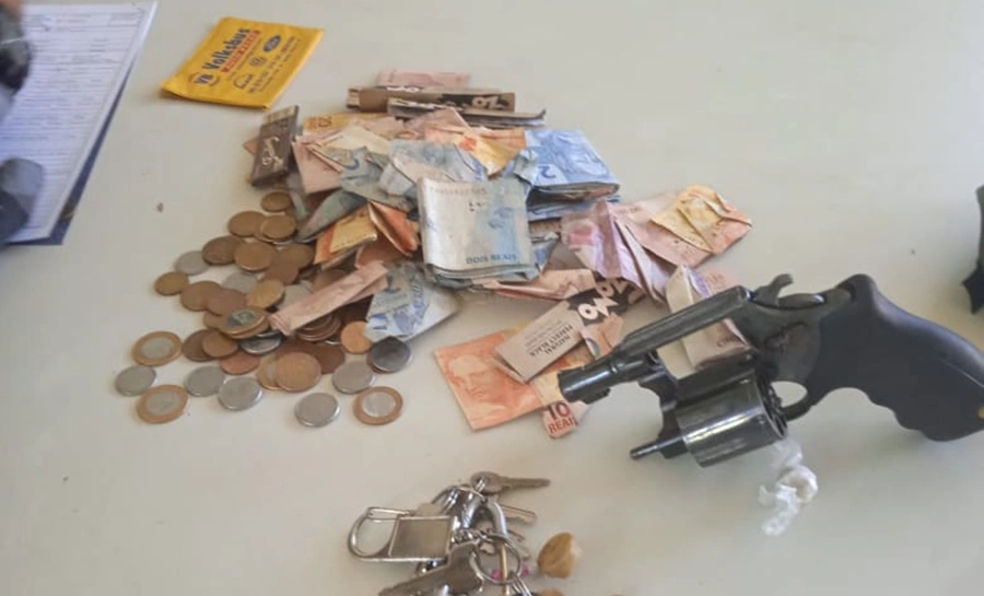 Arma de fogo e dinheiro apreendidos com o suspeito