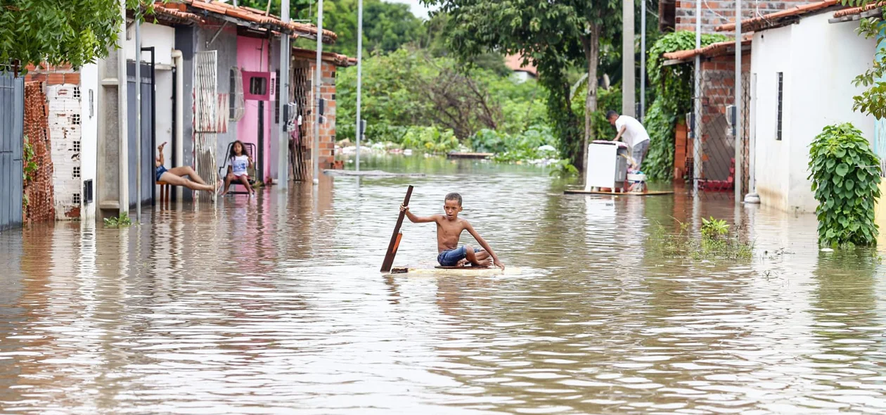 Criança improvisa balsa para se deslocar devido a quantidade de água no local