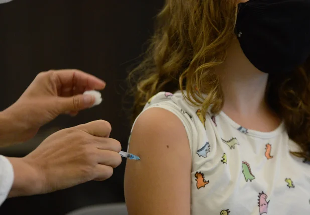 Criança sendo vacinada contra a covid-19