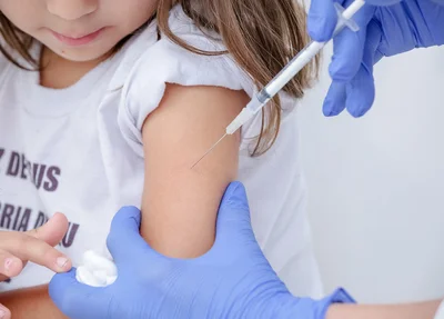 Criança sendo vacinada contra a covid