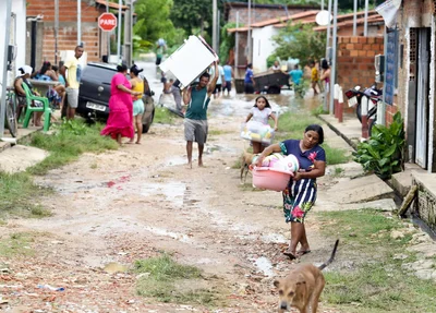 Famílias retiram seus pertences das casas alagadas devido a fortes chuvas em Teresina