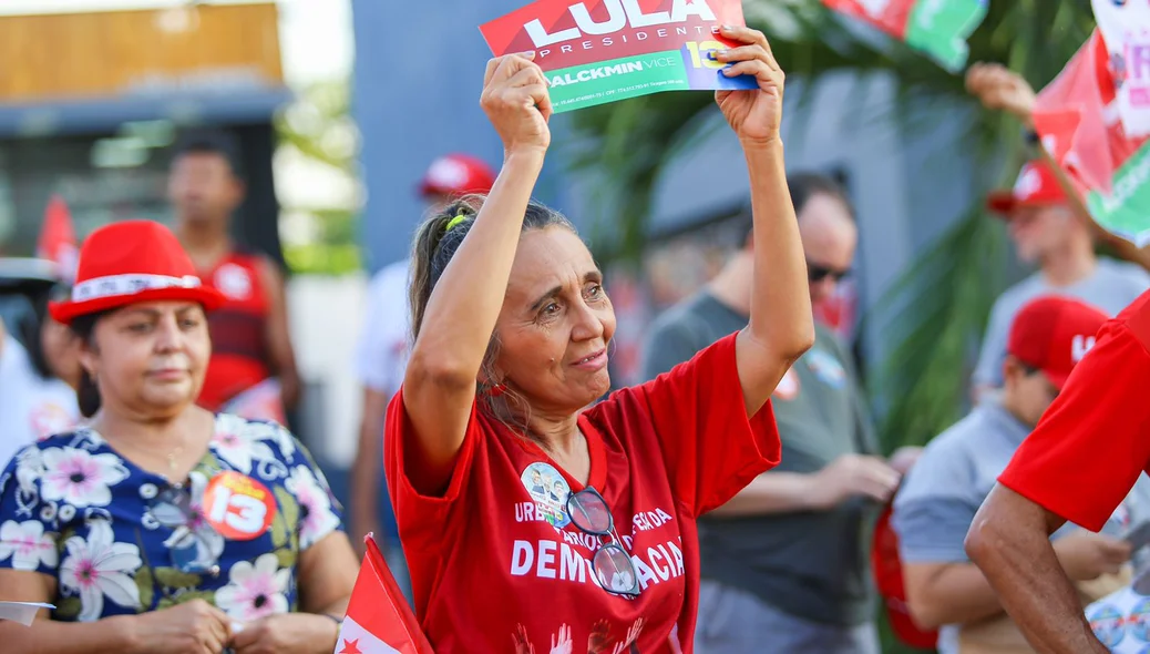 Apoiadora segura cartaz com nome de Lula