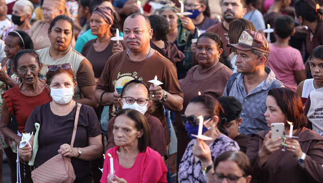 Devotos com velas na procissão
