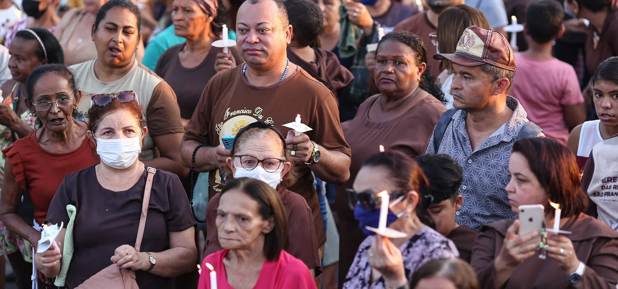 Devotos com velas na procissão