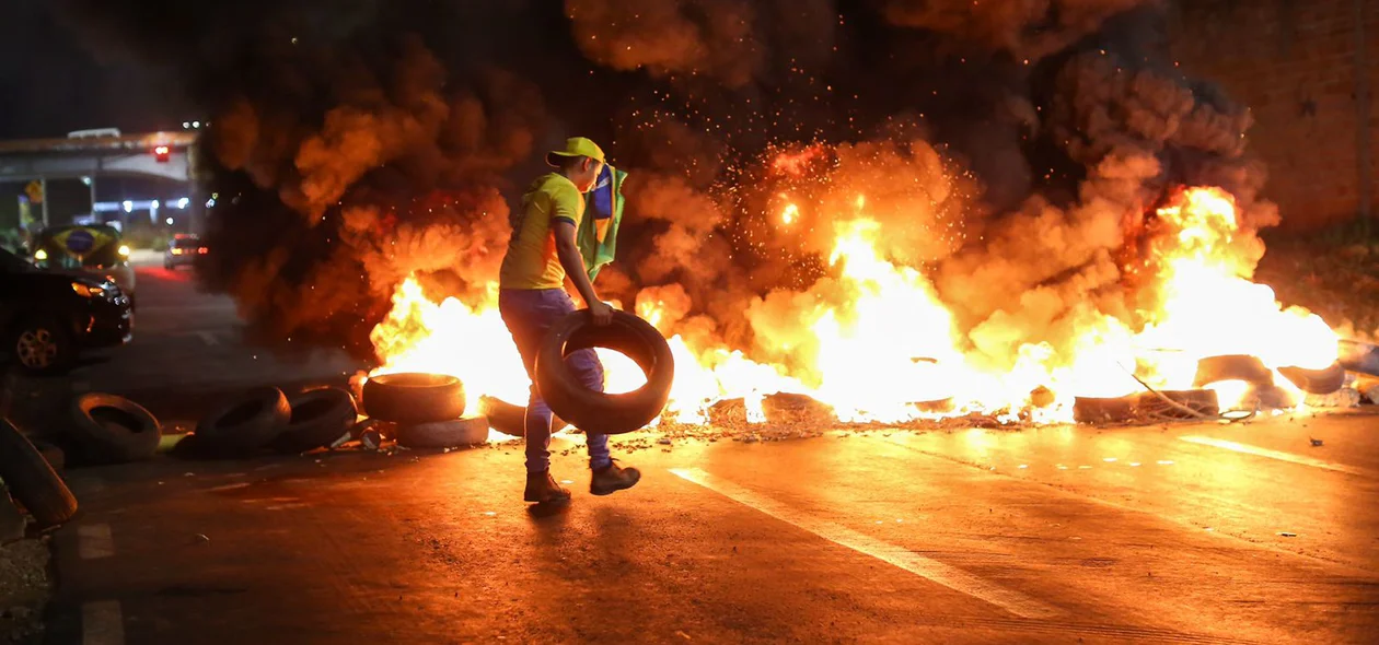 Manifestante ateando fogo em pneus