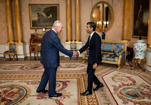 O rei Charles III cumprimenta o novo premiê britânico, Rishi Sunak, no Palácio de Buckingham