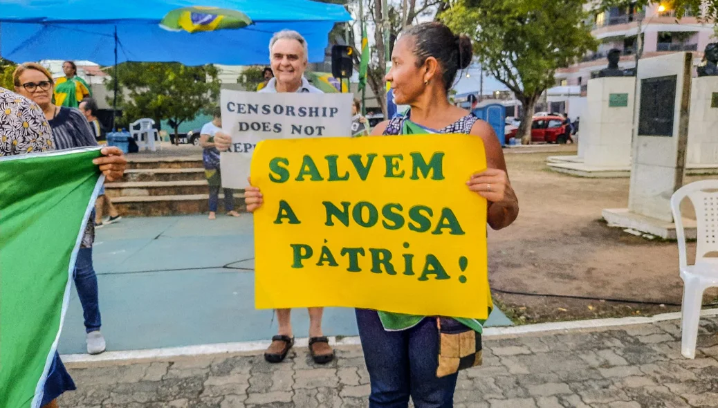 Manifestantes segurando cartazes